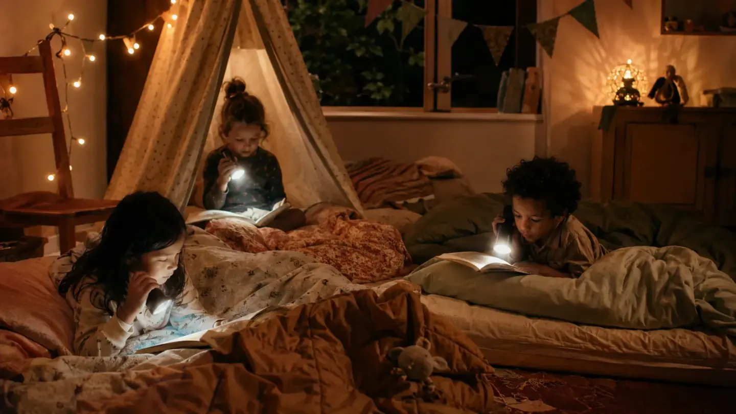 kinderen in slaapzakken op matrassen in een woonkamer met lichtsnoer, ochtendlicht
