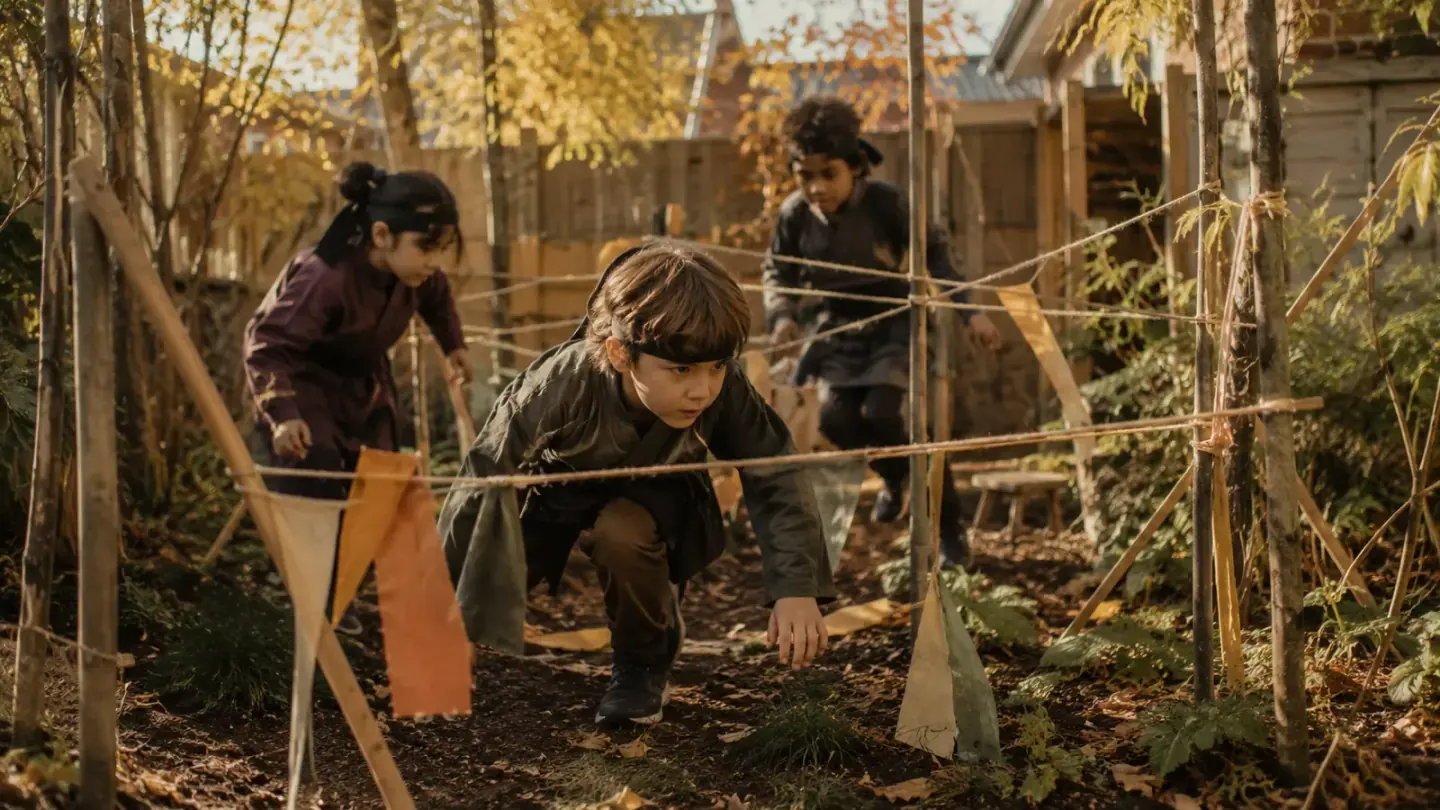 kinderen met zwarte hoofdbanden kruipen door een parcours van touw in de gang