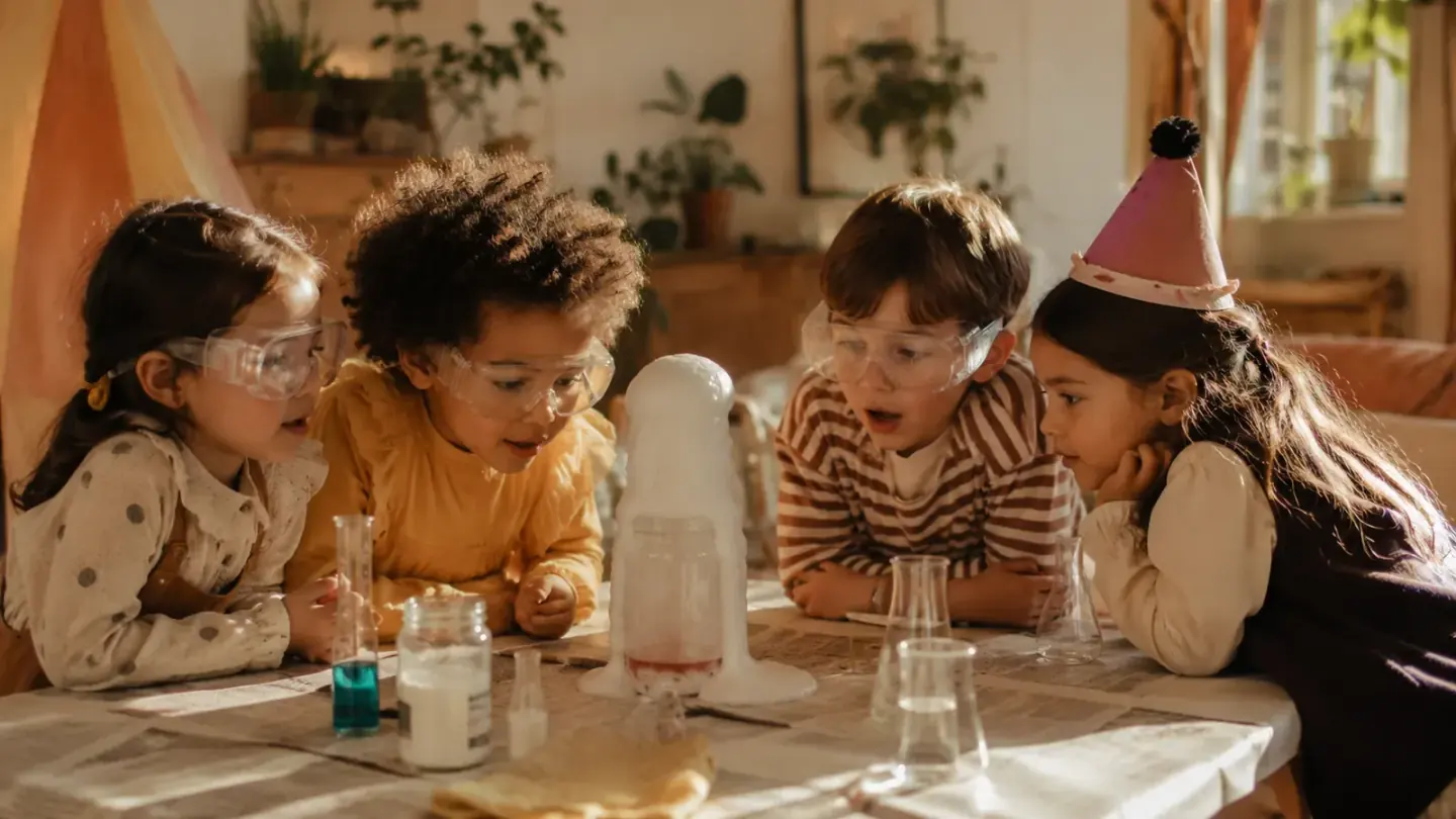 kinderen met veiligheidsbrillen doen een proefje met schuim aan de keukentafel